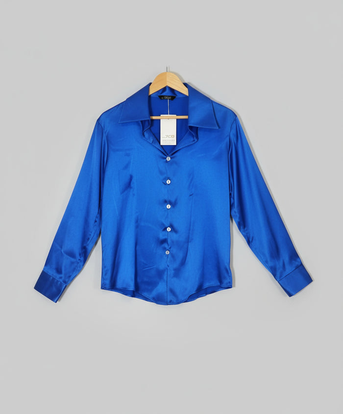 Blue satin shirt on a hanger against a red and white striped background