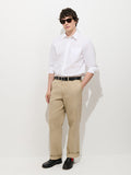 A person wearing a white button-up shirt, the Flat Front Chino in Vintage Wash, a black belt, black shoes, and sunglasses stands against a plain white background with hands in pockets.