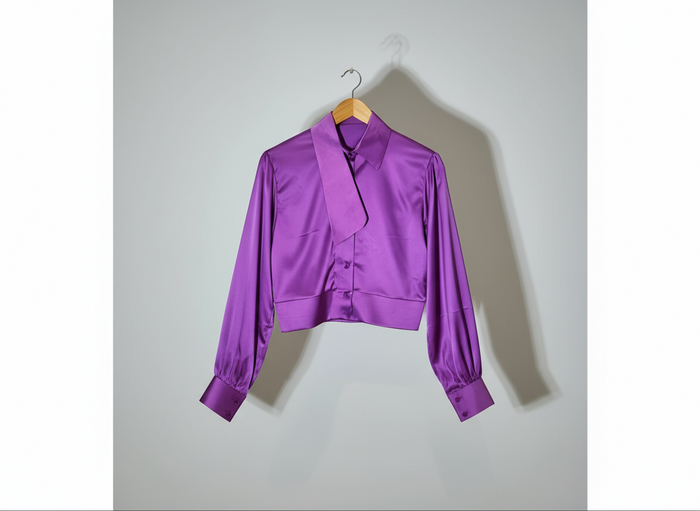 Purple jacket on a hanger against a red and white striped background
