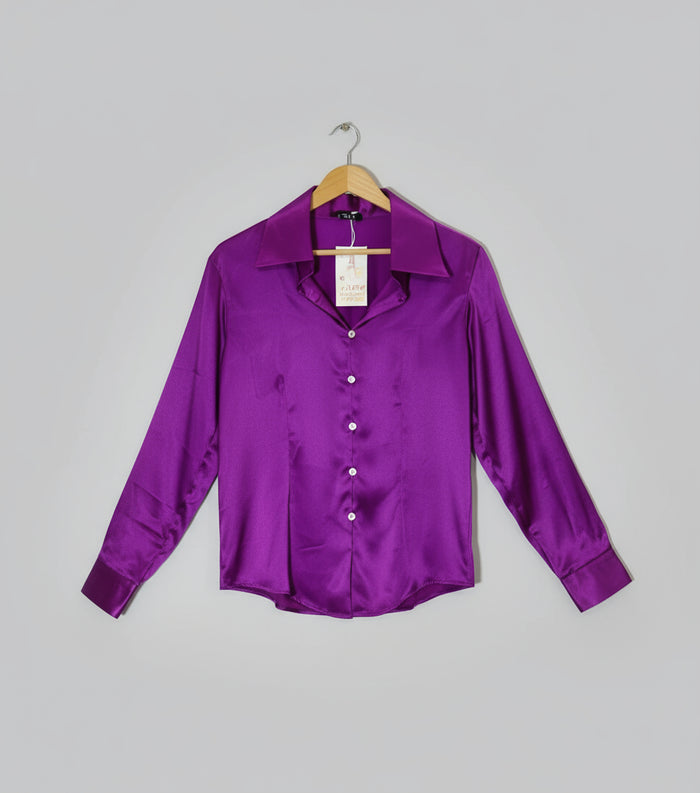 Purple satin shirt on a hanger against a red and white striped background