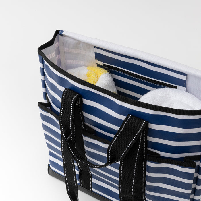 Blue and white striped tote bag with black handles on a white background