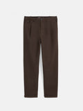 The Standard Pleated Pant in Chino is a pair of brown straight-leg pants featuring front pleats, a button and zip closure, side and back pockets, and crafted from soft cotton twill, shown laid flat on a white background.