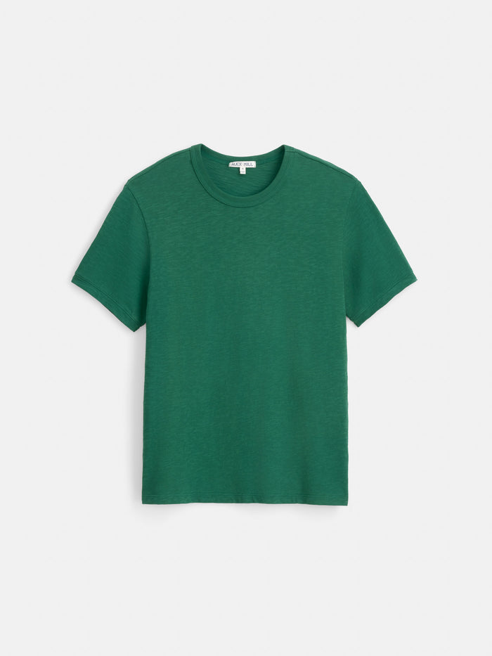 The Standard T-Shirt In Slub Cotton, a men’s short-sleeved tee in green, crafted from breathable slub cotton, is laid flat on a white background.